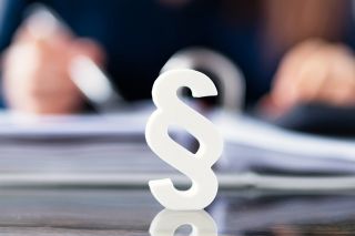 © Andrey Popov - stock.adobe.com Foto: Paragraph vor Aktenmappe